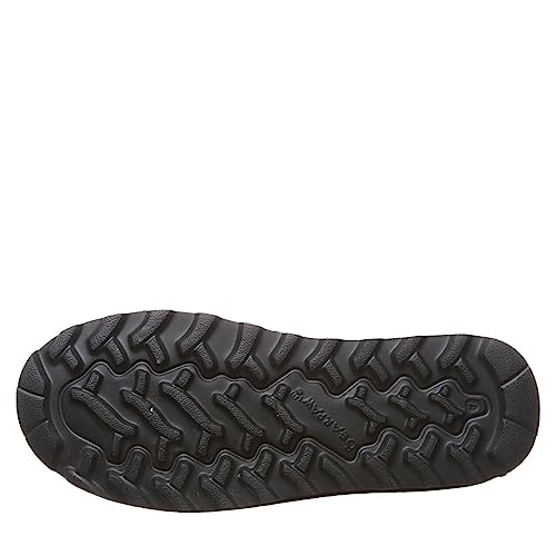 The image shows the black rubber sole of a shoe with a rugged, wavy tread for traction. The center features branding, similar to the BEARPAW Elle Short Vegan Boots - Womens sole with NeverWet technology.