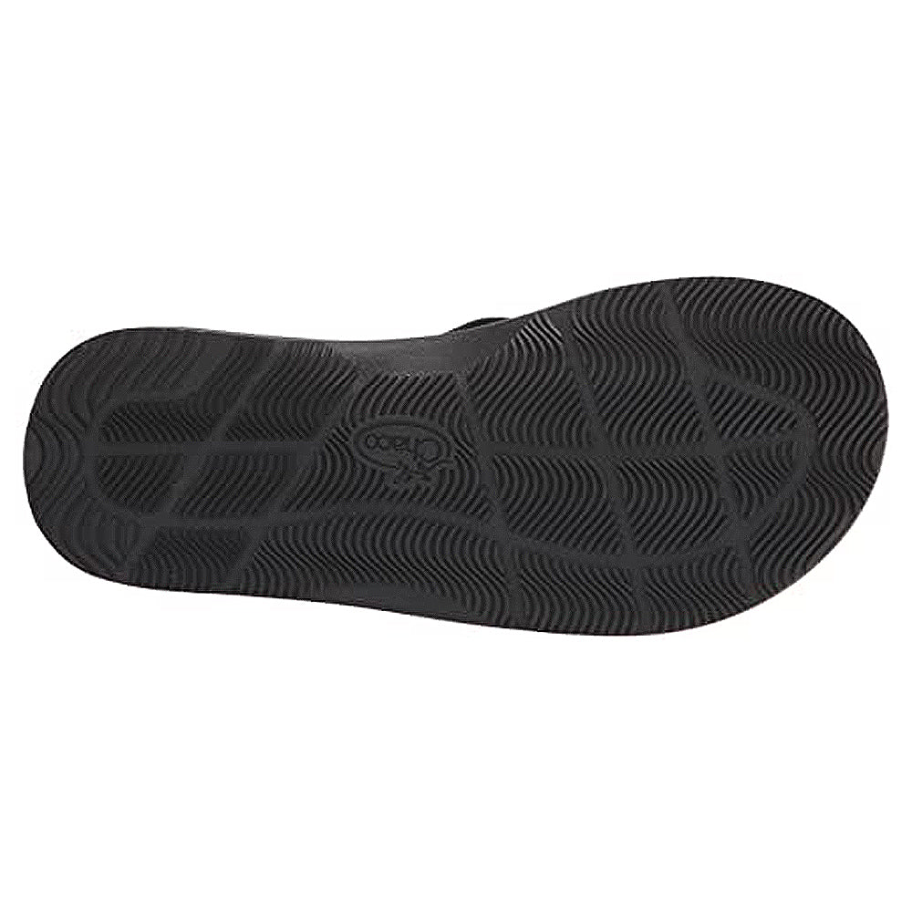 The image shows the black ChacoGrip rubber sole of the Chaco Classic Flip - Men, featuring a wavy, textured tread and the Chaco logo embossed near the center.