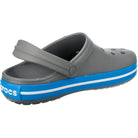 The Crocs Crocband Clog Seasonal Colors - Unisex features a gray upper with ventilation holes, blue and white striped sole, and a secure heel strap—available now.