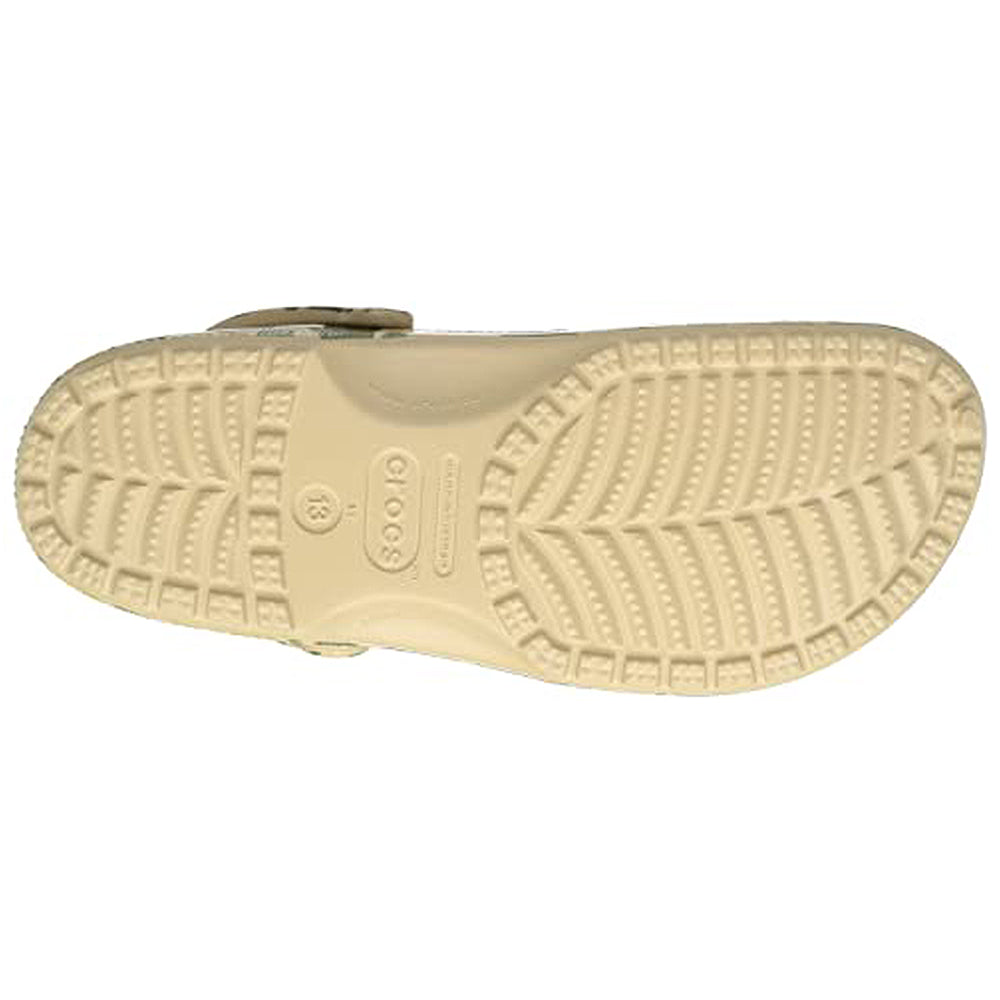 The image displays the beige sole of the Crocs Classic Camo Clog - Unisex, showcasing textured tread and a central Crocs logo. These slip-on shoes are praised for their comfort and versatility as water-friendly footwear.
