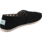 The TOMS Alpargata - Womens features a black slip-on canvas upper, white sole, zigzag inner lining, and blue heel label. Part of the earthwise collection, its made with recycled cotton.