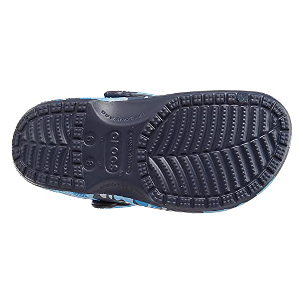 The image shows the sole of a Crocs Classic Camo Clog - Unisex, featuring a textured tread for grip and the Crocs logo embossed in the center, highlighting these comfortable unisex slip-on water shoes.