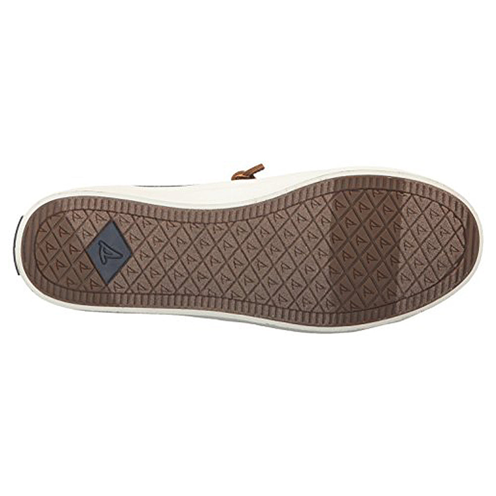 The image shows the sole of the Sperry Crest Vibe - Womens sneaker, featuring a brown, diamond-patterned tread with small triangular logos and a dark rectangular logo near the heel. The side of the sole is white.