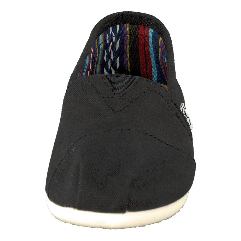 A front view of the TOMS Classic Canvas - Men shoe in black, featuring a white sole, colorful striped inner lining, and a convenient slip-on design.