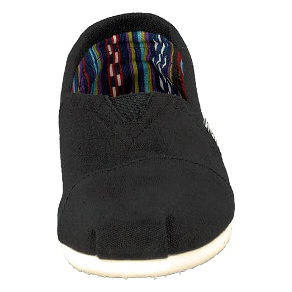 The TOMS Classic Canvas - Men is a black slip-on shoe with a rounded toe, white sole, and colorful striped inner lining. Styled after classic TOMS Shoes, it’s shown facing forward.