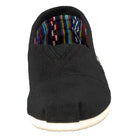 The TOMS Classic Canvas - Men is a black slip-on shoe with a rounded toe, white sole, and colorful striped inner lining. Styled after classic TOMS Shoes, it’s shown facing forward.