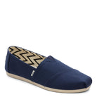 The TOMS Alpargata ESP - Women features a navy canvas upper, beige sole, and zigzag inner lining, shown from the side and front—reflecting TOMS’ signature buy one give one spirit.