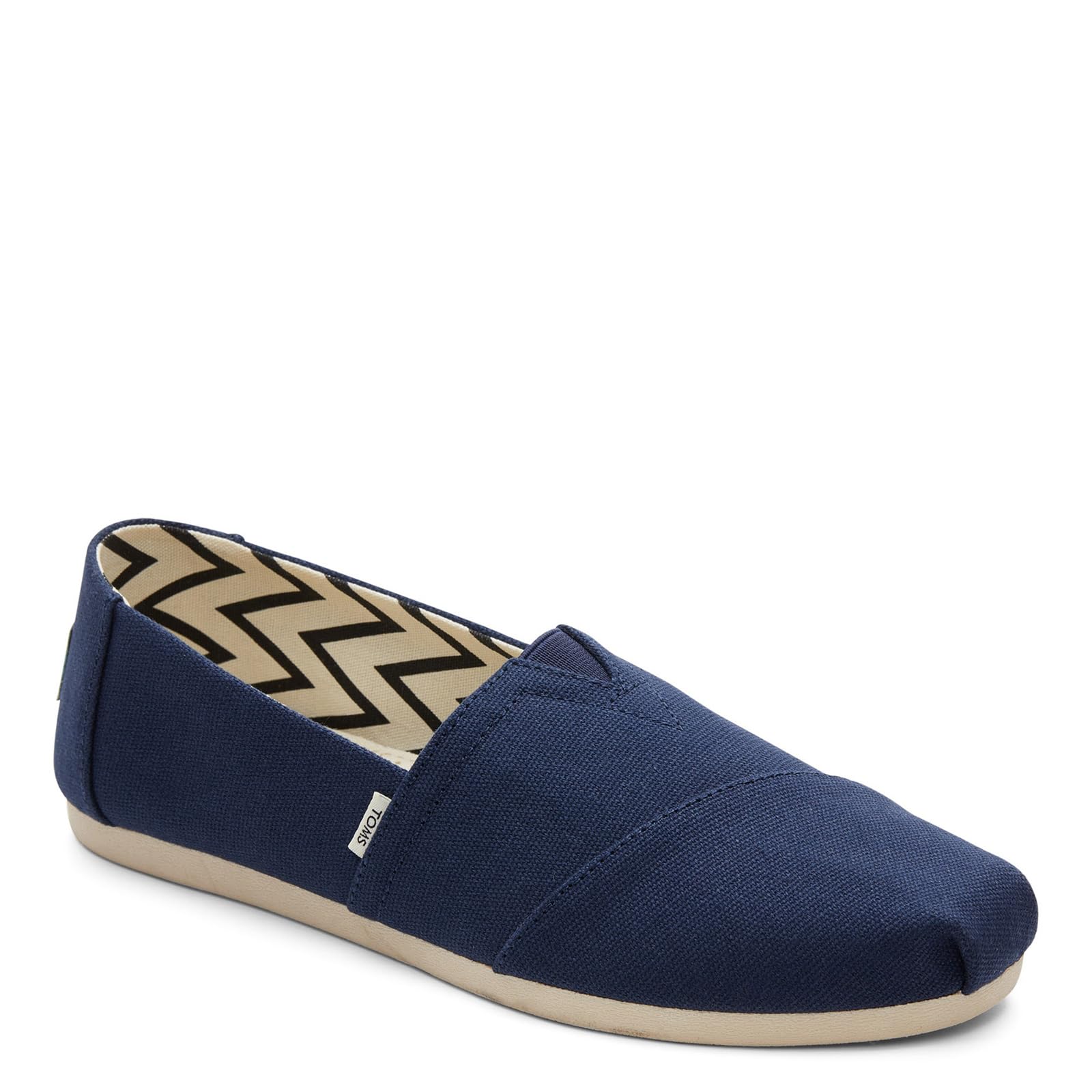 The TOMS Alpargata ESP - Women features a navy canvas upper, beige sole, and zigzag inner lining, shown from the side and front—reflecting TOMS’ signature buy one give one spirit.
