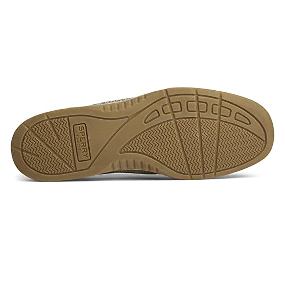 The image shows the tan rubber sole of the Sperry Bluefish - Women boat shoe, with wave-like tread patterns, linear grooves, and the Sperry brand name embossed near the heel.