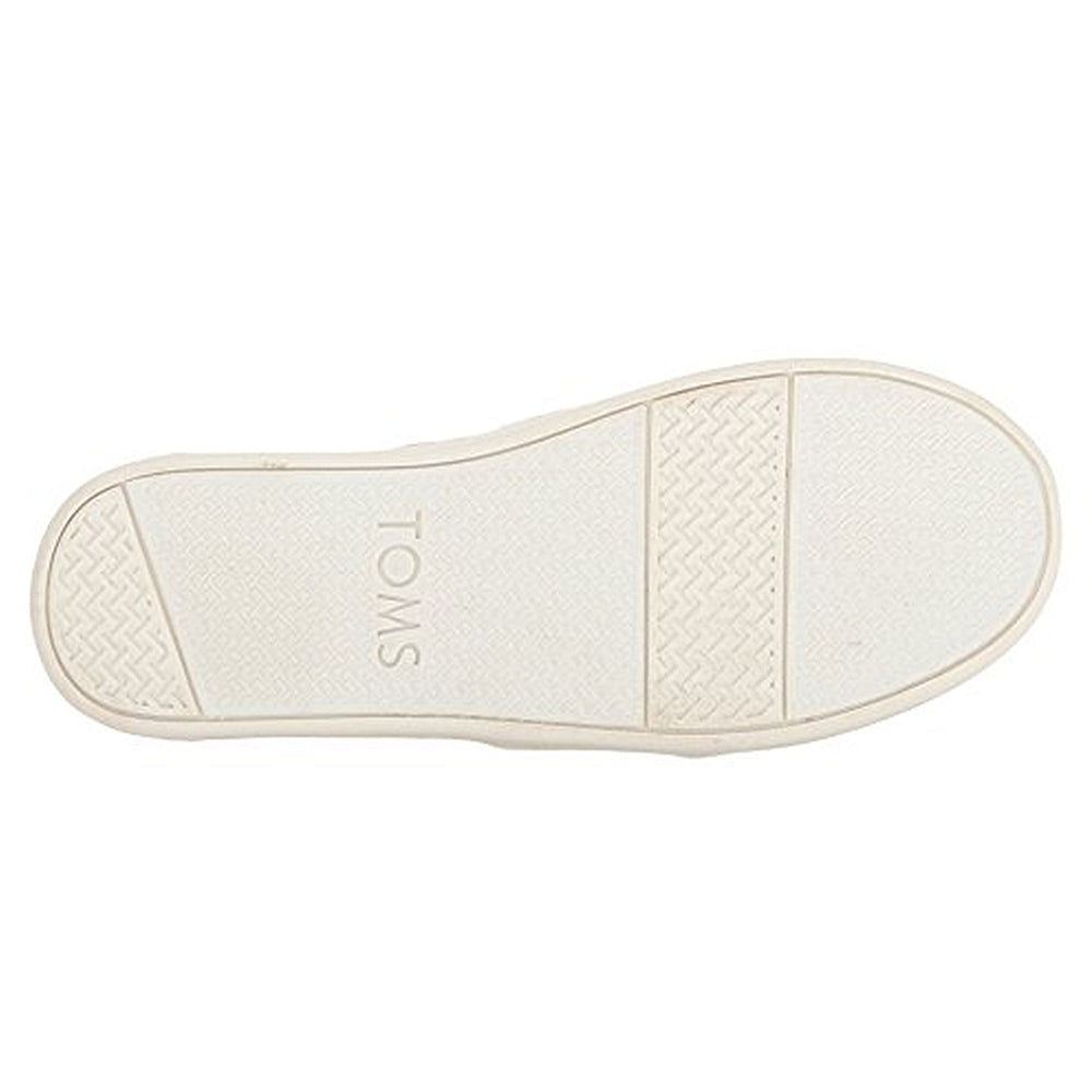 The image shows the white rubber sole of the TOMS Alpargata ESP - Women slip-on, featuring TOMS at the center. The tread has textured grips at the toe and heel, with a smoother middle section.