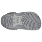 The underside of a single Crocs Classic Clog - Kids in gray shows the tread pattern with grip grooves, plus Crocs branding and size info at the center of the sole.