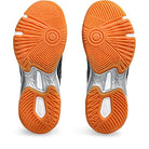 Two orange-soled ASICS Gel-Rocket 11 - Womens shoes are shown from the bottom, displaying textured treads with black, white, and gray details in circular and triangular patterns for added stability.