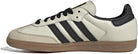 The adidas Samba OG - Women features a beige leather upper, black stripes and laces, a black heel, and a gum rubber sole, shown in a side view.