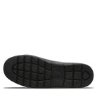 The image displays the black rubber outsole of BEARPAW Harry Slippers - Mens, featuring a patterned tread with square and round textures plus a central logo, offering grip ideal for cozy wear.