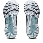 The image displays the outsoles of ASICS Gel Kayano 29 - Mens running shoes in white, black, and teal, featuring textured grooves and a wavy tread for enhanced traction and stability.