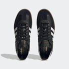 A pair of adidas Samba Decon Shoes for men with a black leather upper, white stripes, and gold logo details, shown from above on a light gray background.