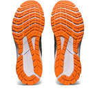 Two orange and white ASICS GT-1000 11 - Mens running shoe soles with black details are displayed side by side, showcasing their tread patterns and FLYTEFOAM cushioning against a white background.
