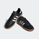 The adidas Samba Decon Shoes - Men, featuring a black leather upper, signature white stripes, and gum rubber soles, are shown against a light gray background.