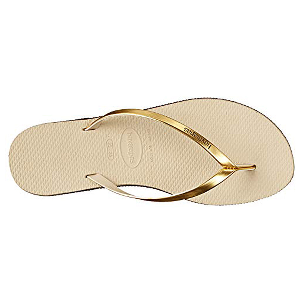 A single beige Slim Metalic sandal for women by Havaianas, featuring shiny gold straps and a textured sole, viewed from above in a classic style.