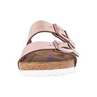 Front view of the Birkenstock Arizona - Womens sandal, featuring a chunky cork sole, white bottom, and two buckled metallic rose gold straps for orthopedic walking comfort, inspired by classic Birkenstock design.