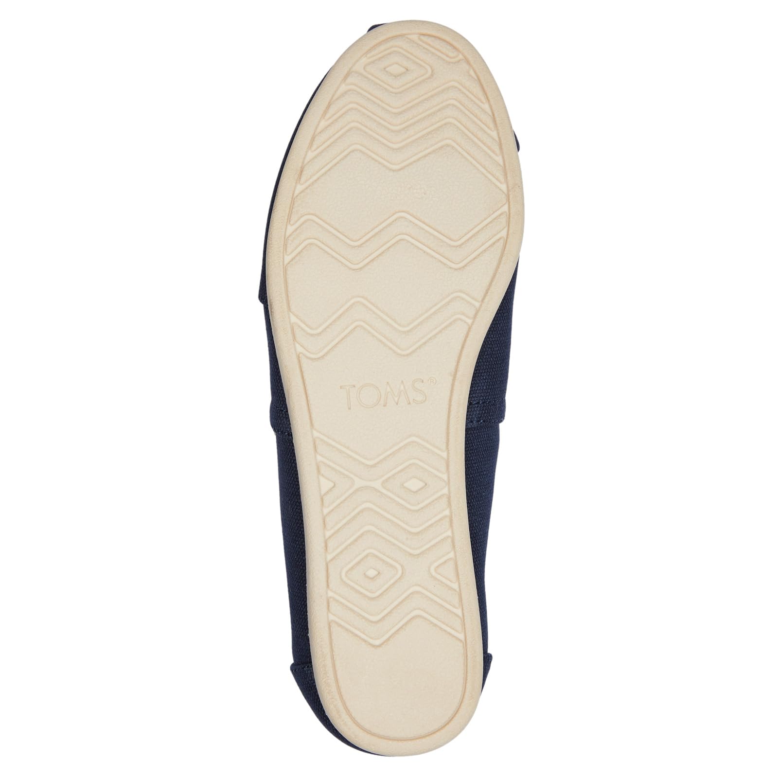 The Alpargata ESP - Women by TOMS features a navy blue slip-on design with a sole that has a light-colored rubber bottom, zigzag and diamond tread pattern, and the TOMS brand name embossed in the center.