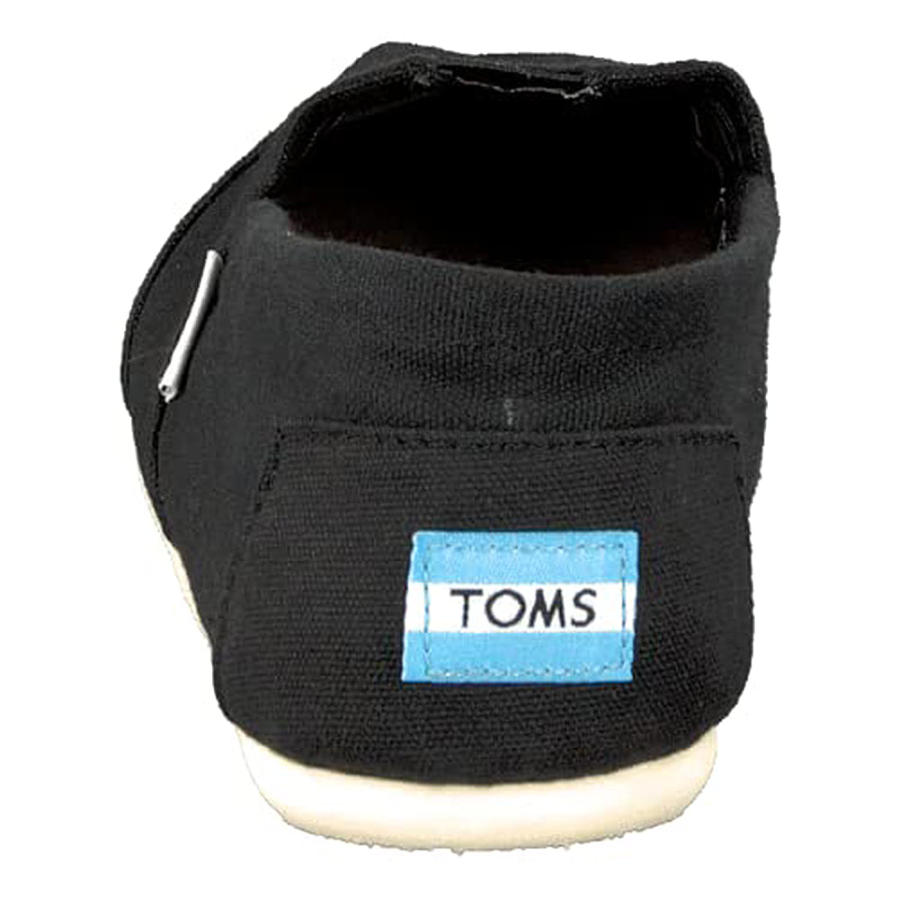 The Classic Canvas - Men slip-on by TOMS is shown from the back in black canvas, with a light blue and white TOMS label on the heel and finished with a white rubber sole.