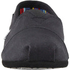 Front view of the TOMS Classic Canvas - Men slip-on in black, featuring a rounded toe, visible stitching, and an interior with the brands signature colorful striped lining.