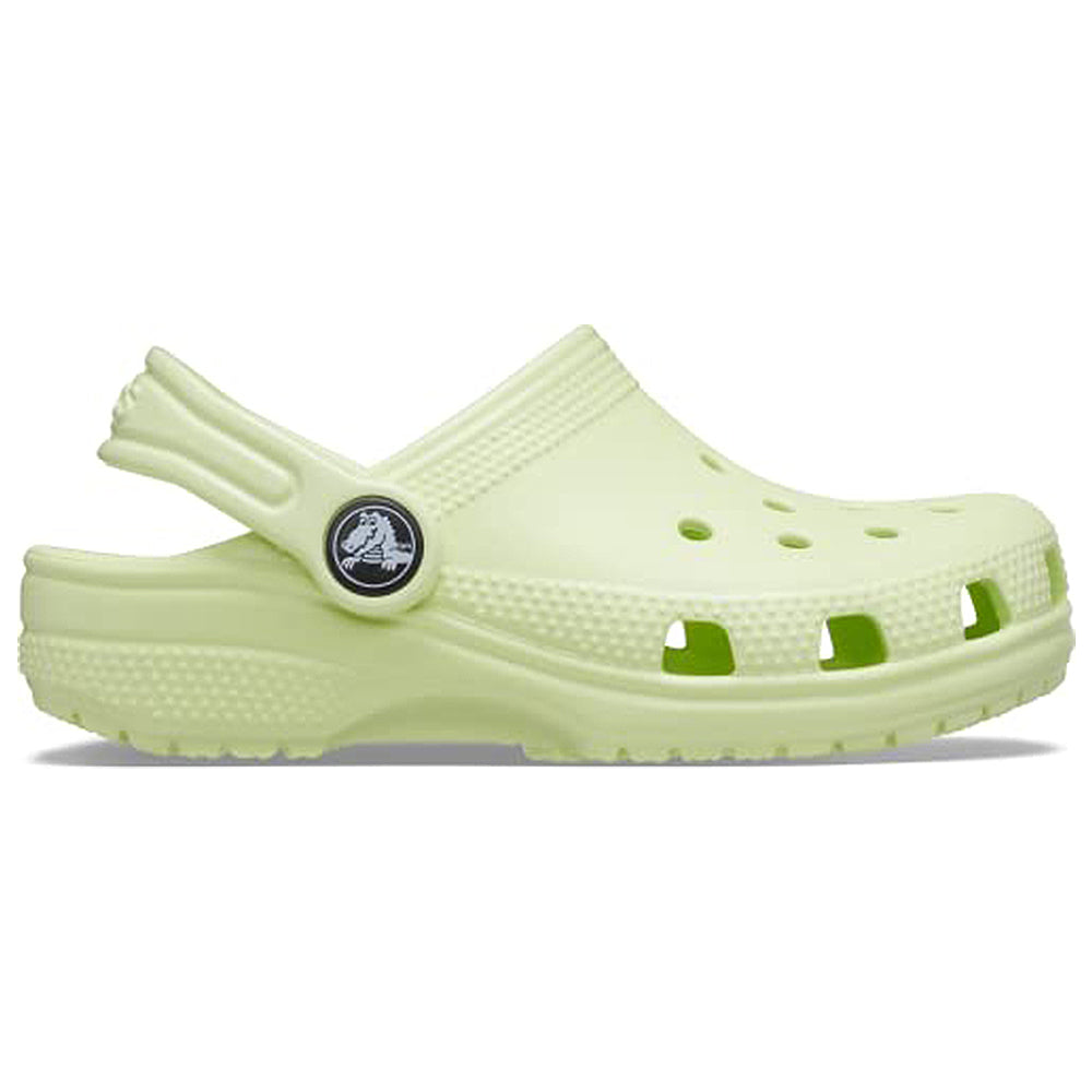 The Crocs Classic Clog - Kids is shown in light green with ventilation holes, a textured sole, and an adjustable heel strap in a side profile on a white background.