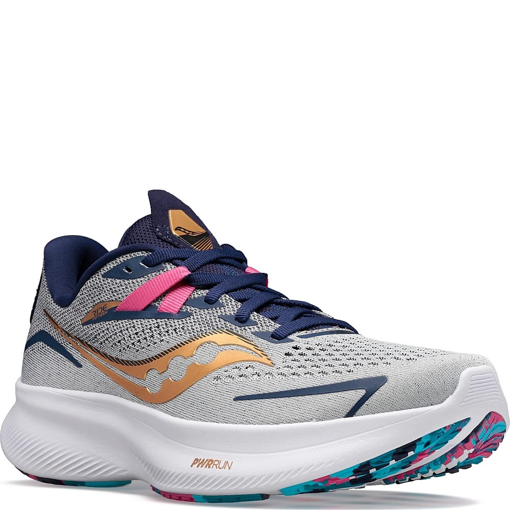 The Saucony Ride 15 - Womens is shown in gray with navy, pink, and gold accents, a white PWRRUN cushioned sole, and a patterned outsole, displayed in an angled side view.