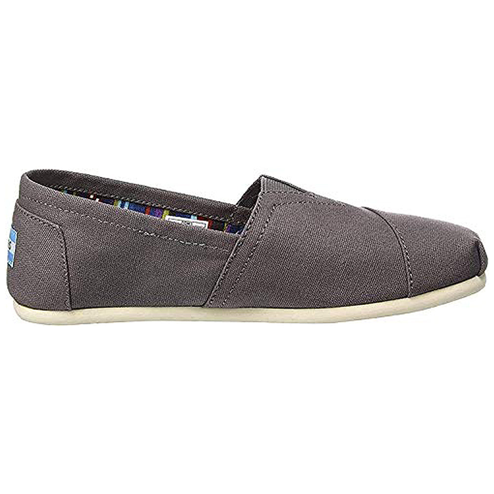 The TOMS Classic Canvas - Men is a gray slip-on shoe with a white sole, featuring the iconic alpargata silhouette and low profile—a timeless design from TOMS.