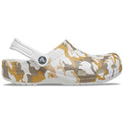 The Crocs Classic Camo Clog - Unisex features a tan, white, and brown camouflage design with a white strap. These comfortable slip-on water shoes are perfect for everyday wear, shown from the side on a plain white background.