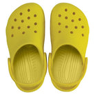 A pair of Crocs Classic Clog - Kids in bright yellow, featuring ventilation holes and adjustable heel straps, is shown from above on a white background.