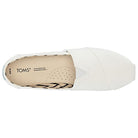 Top view of the Alpargata - Womens slip-on by TOMS, featuring a white upper, beige insole with black patterns and perforations for breathability. Part of the earthwise collection with recycled cotton; TOMS logo printed near the heel.