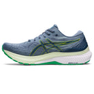 The ASICS Gel Kayano 29 - Mens running shoe in blue and green features a white sole, yellow ASICS logo on the side, a textured upper for enhanced stability, and green accents on the outsole.