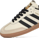 The adidas Samba OG - Women features a cream leather upper, black stripes and laces, beige suede toe, gold adidas branding on the tongue, and a gum rubber sole—classic style reimagined for women.