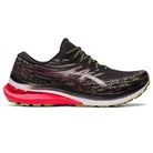 The ASICS Gel Kayano 29 - Mens running shoe features a black upper with gold and silver accents, a shiny silver ASICS logo, red midsole detail, and a yellow-green sole, offering a sleek look with enhanced stability for your runs.