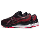 A pair of ASICS Gel Kayano 28 - Mens stability running shoes in black and red, featuring white midsoles and pink outsoles, are displayed side by side at an angle on a white background.