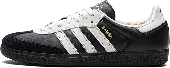 The adidas Samba OG - Men features a black and white leather upper, three white stripes, white laces, and gold SAMBA lettering on the side—an iconic sneaker for timeless street style.