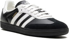 The adidas Samba OG - Men is a black and white sneaker with a leather upper, iconic white stripes, white laces, and gold SAMBA text on the side—ideal for classic street style. Shown on a white background.