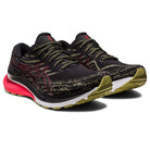 The ASICS Gel Kayano 29 - Mens features a black knit design with olive green patterned details, red accents, and olive green soles. The prominent ASICS logo ensures style and stability with every stride.