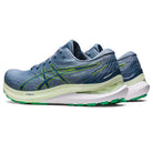A pair of mens ASICS Gel Kayano 29 running shoes in blue with neon green and yellow accents, white sole, and green tread, shown at an angle to display the side and back for optimal stability.
