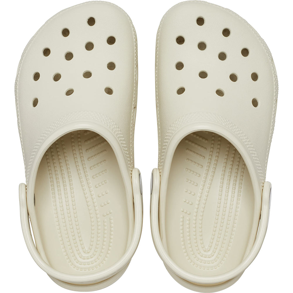 The Crocs Classic Clog - Kids in cream has ventilation holes, textured insoles, adjustable heel straps, and rounded toes for comfort and support. A top view shows these classic kids shoes by Crocs.