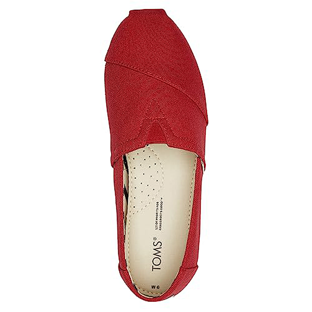Top view of the TOMS Alpargata ESP - Women, a red slip-on shoe with a beige insole. Features TOMS branding and size print inside, visible stitching details, and represents the brand’s buy one give one philosophy.