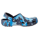 The Crocs Classic Camo Clog - Unisex features a blue and navy camouflage pattern, ventilation holes, and an adjustable heel strap, offering comfortable, water-friendly slip-on style perfect for all-day wear.