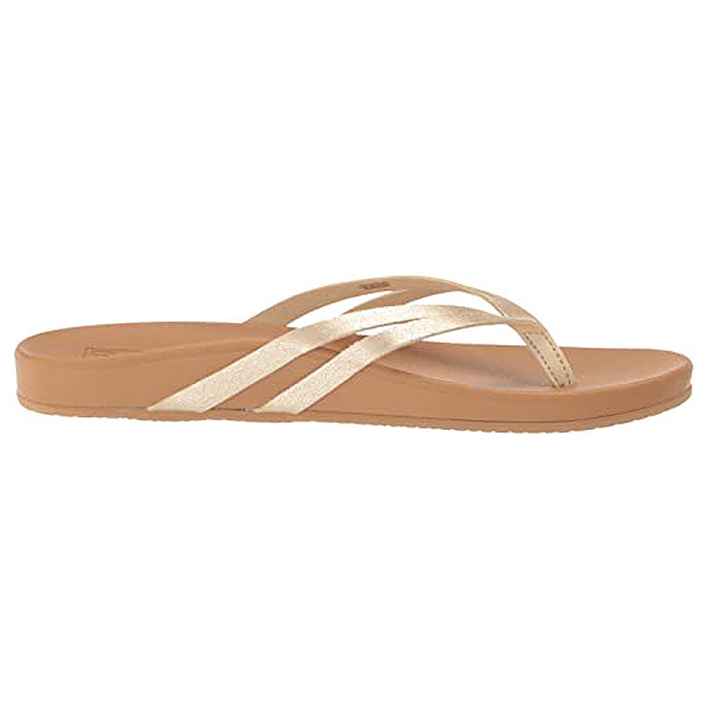 The Reef Cushion Spring Joy - Womens sandal features a tan design with three thin metallic gold straps, an open toe, and a cushioned footbed for comfort, inspired by classic Reef sandals.
