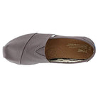 A top view of a single gray TOMS Alpargata ESP - Women slip-on with a canvas upper, tan padded insole, and small TOMS label by the elastic V-insert—showcasing the brands signature buy one give one promise.