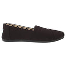 The TOMS Alpargata - Womens slip-on in black features recycled cotton canvas from their earthwise collection, a flat sole, closed toe, and a simple side profile. The inner lining showcases a black and white chevron pattern.