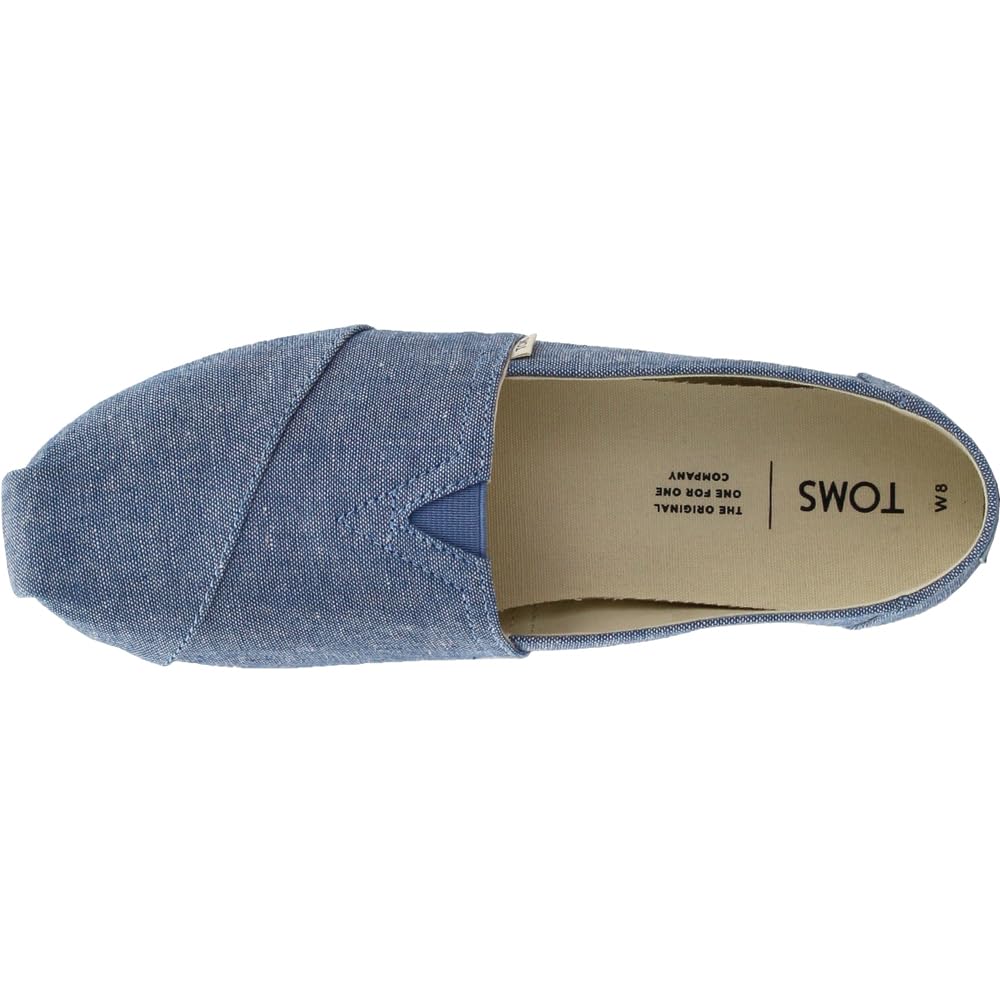 Top view of the TOMS Alpargata ESP - Women slip-on in blue with a tan insole labeled TOMS and W8, featuring a V-shaped elastic insert, simple stitching, and part of their buy one give one initiative.