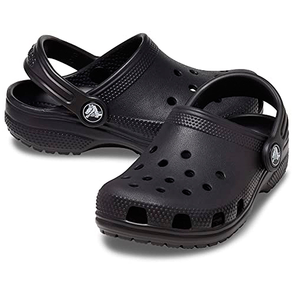 The Crocs Classic Clog - Kids in black features ventilation holes, an adjustable heel strap, and textured soles, shown against a white background.