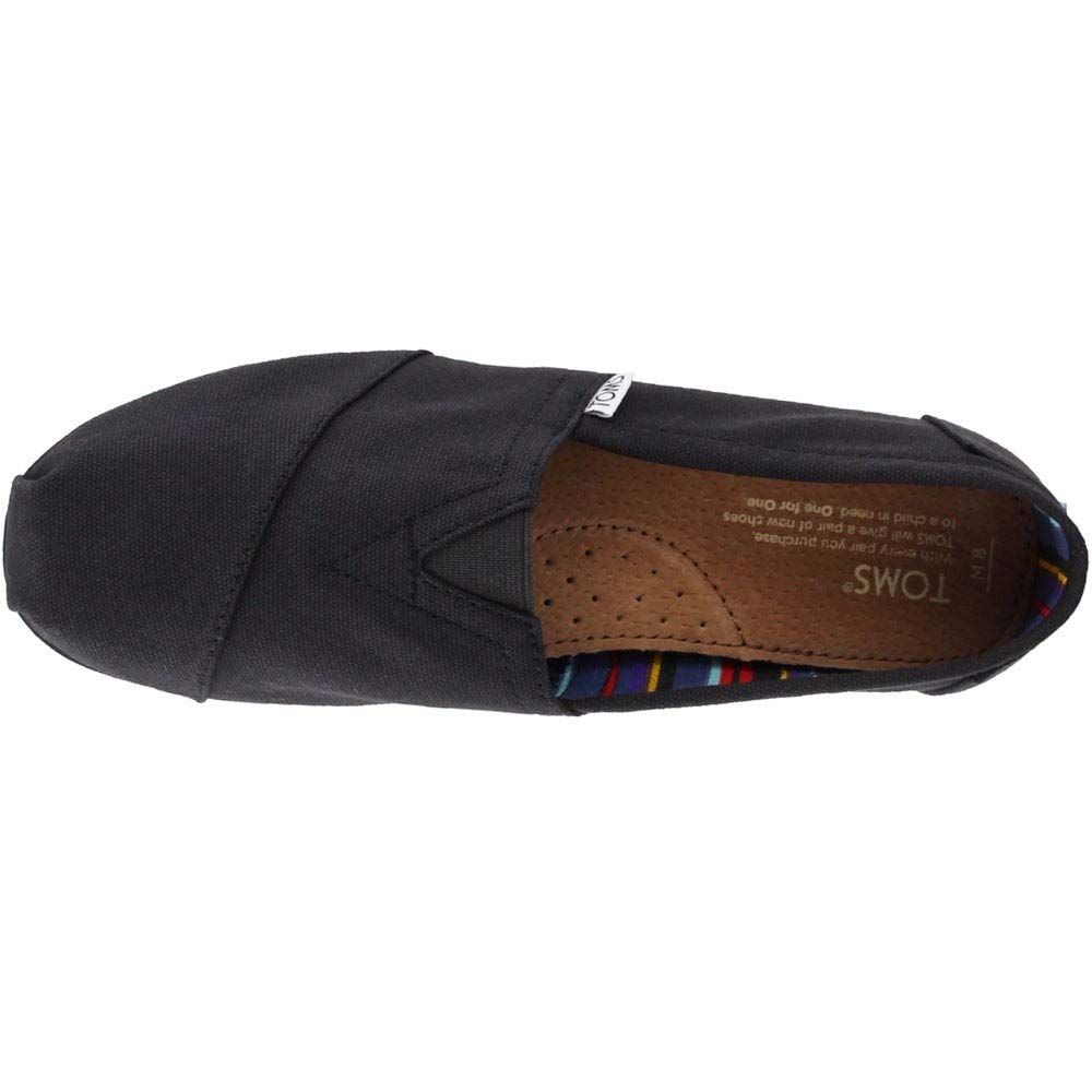 Top view of the TOMS Classic Canvas - Men slip-on in black, with a brown insole and colorful striped heel lining, featuring TOMS branding on the insole and outer tag.